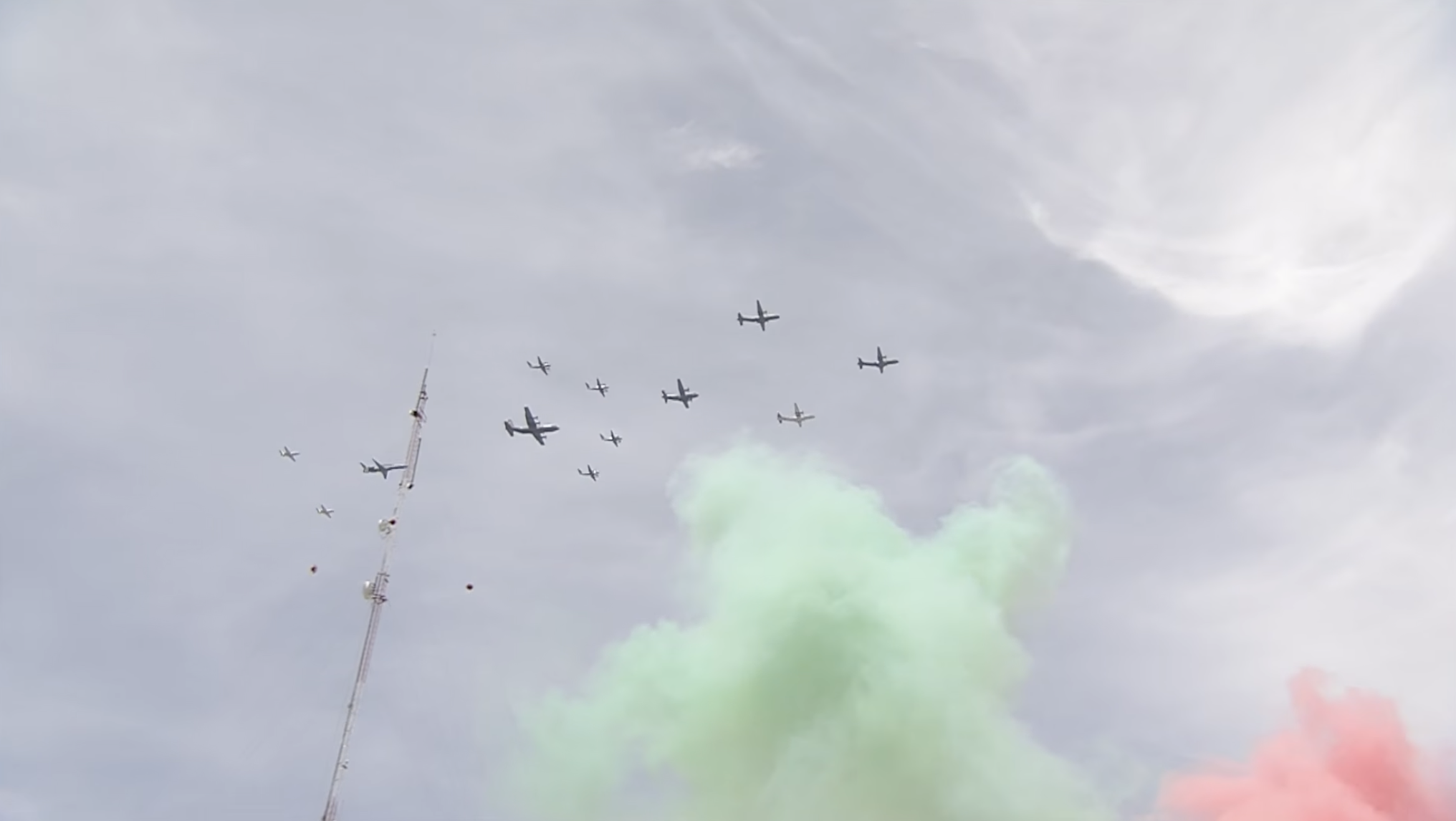 Formación en masa de aeronaves militar de la Fuerza Aérea Mexicana y la Guardia Nacional surcando el cielo del Zócalo capitalino, acompañadas por humo tricolor (verde, blanco y rojo) durante el Desfile Militar.