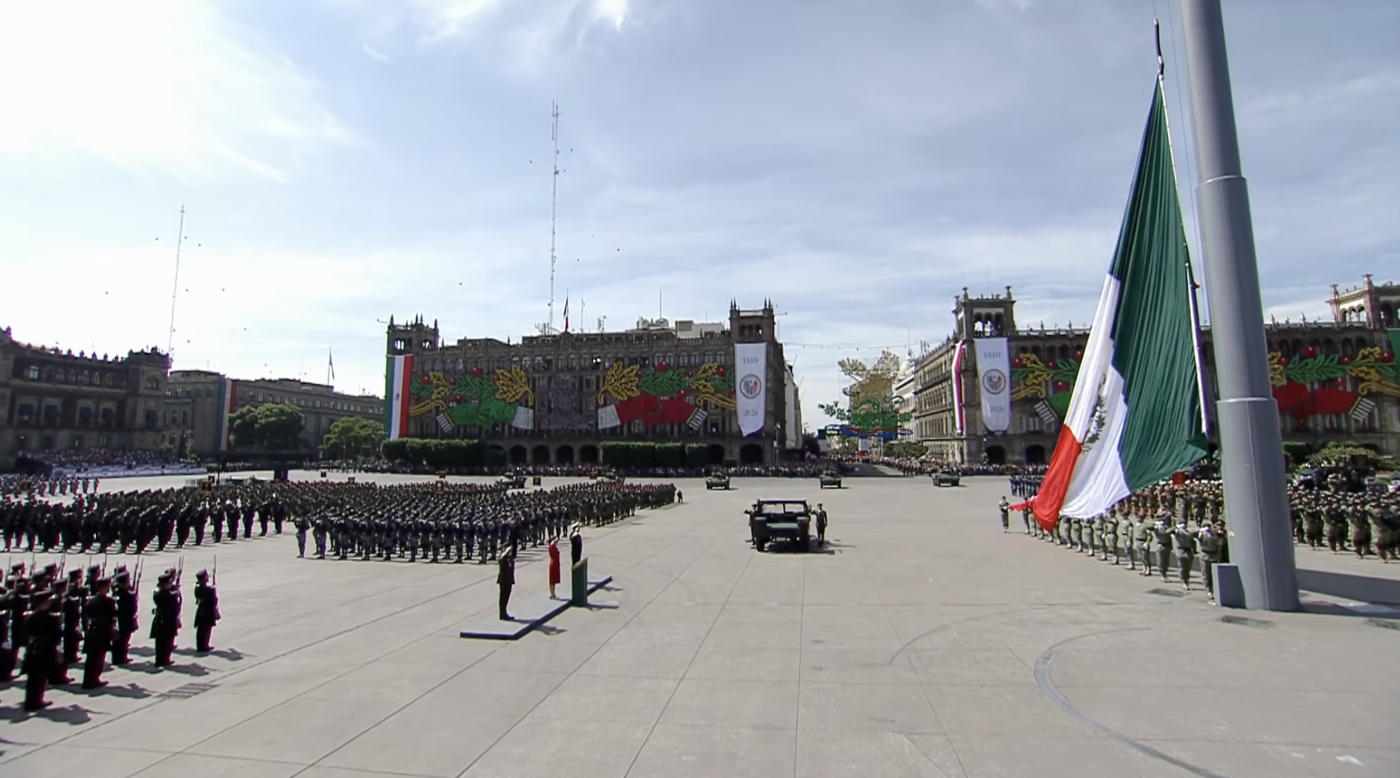 Ceremonia del 16 de septiembre en el Zócalo de CDMX con tropas y adornos patrios. Claudia Sheinbaum preside el acto frente al Palacio Nacional. Banderas monumentales y edificios decorados para la Independencia de México.