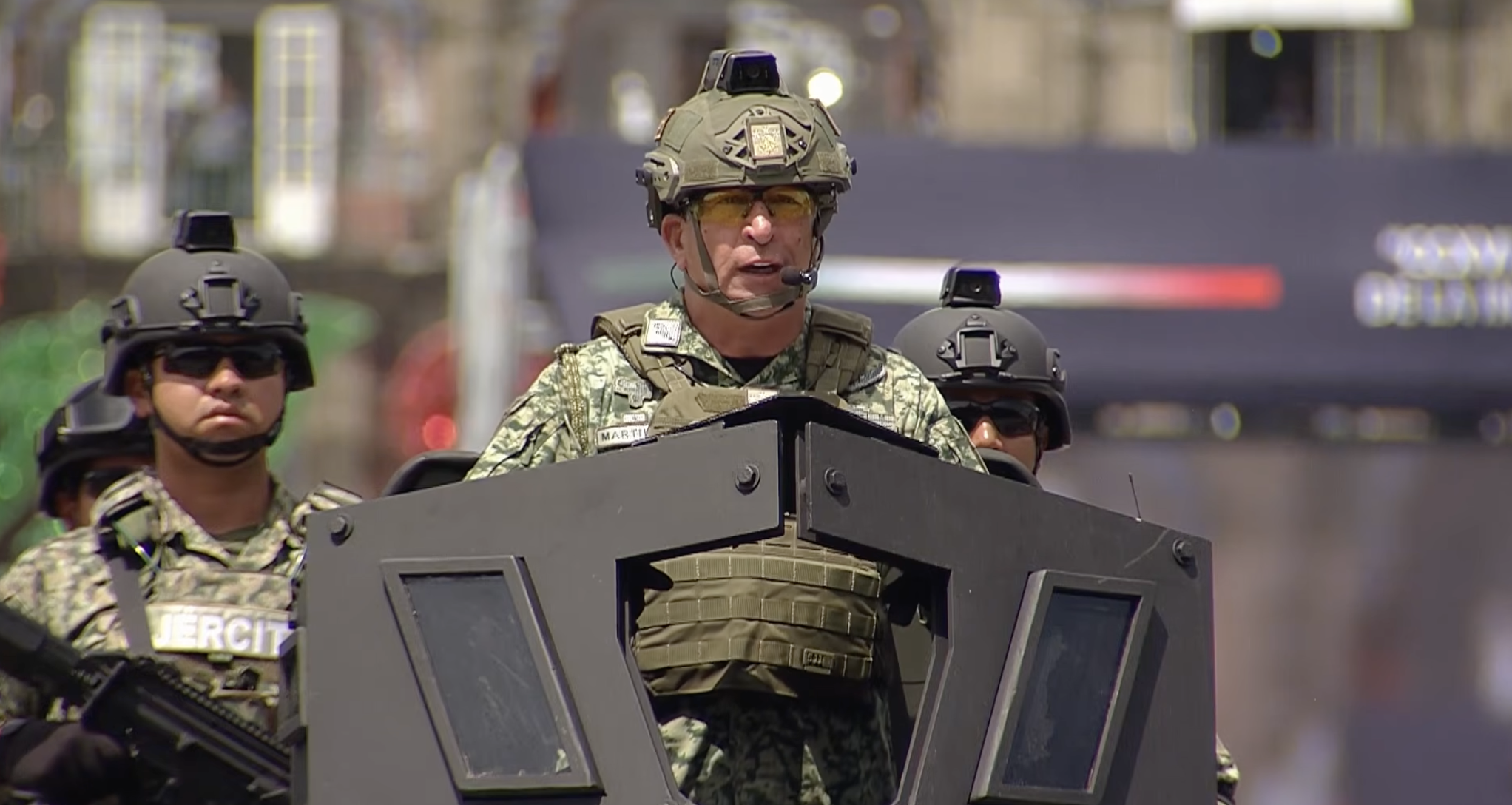 El general Enrique Martínez López, subsecretario de la SEDENA y comandante de la columna del desfile, a bordo de un vehículo táctico blindado luciendo casco táctico, chaleco y equipo de comunicación durante el Desfile Militar